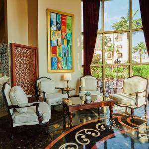 - un salon avec des chaises, une table et une fenêtre dans l'établissement Crowne Plaza Riyadh Al Waha, an IHG Hotel, à Riyad