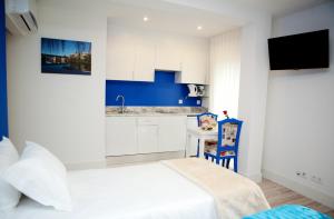 a small room with a bed and a kitchen at Top'Otel in Barcelos