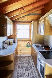 a kitchen with wooden cabinets and a stove top oven at Ferienhaus Bergglück in Nonnweiler