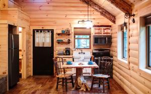 una cocina con mesa y sillas en una cabaña en Cricket Hill Treehouse D by Amish Country Lodging en Millersburg