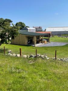 a building in a field with a grassy field at Famau Cabins Gwel Y mynudd in Cilcain