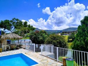 a house with a swimming pool and a fence at Sítio Gazotti Marina in Capitólio