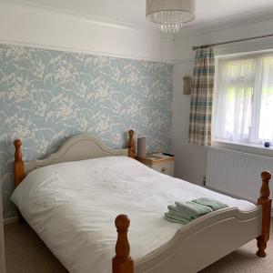 萊姆里吉斯的住宿－Nettle Bank，一间卧室配有一张蓝色花卉壁纸床