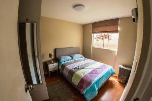 um pequeno quarto com uma cama e uma janela em Apartamento 3 Habitaciones Lima, Perú (Magdalena del Mar) em Lima