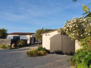 un estacionamiento con un edificio y un garaje en Ma Chambre d'Amis en Saint-Clément-des-Baleines