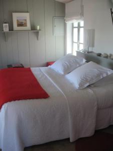a bedroom with a white bed with a red blanket at Ma Chambre d'Amis in Saint-Clément-des-Baleines