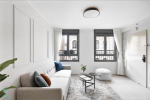 a white living room with a couch and a table at Mate ALMA - By HOMY in Jerusalem