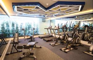 a gym with several treadmills and exercise bikes at The Beach Condotel Kata 500 maters to the beach in Kata Beach