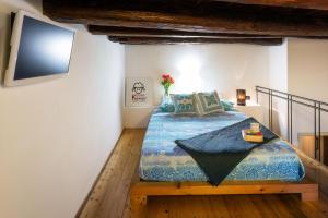 a bedroom with a bed and a tv on the wall at Casa Kawaii in Cagliari
