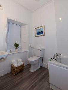 a white bathroom with a toilet and a sink at Fernbank House in Aberfeldy