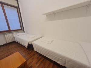 a room with two beds and a table and a window at BRERA - ForoBuonaparte Cozy apartment in Milan