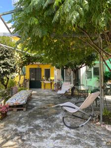 un patio con una silla y un sofá bajo un árbol en CASA MIMOSA: relax, vista mare, parcheggio gratis, en San Remo 18 fotos más