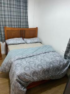 1 dormitorio con 1 cama con manta y almohadas en Lovely 2 Bedroom Apartment with free parking en Mánchester