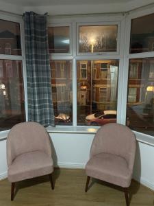 dos sillas sentadas frente a una ventana en Lovely 2 Bedroom Apartment with free parking en Mánchester