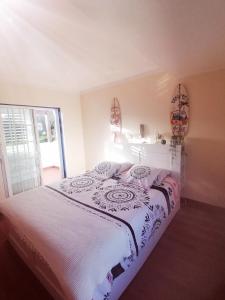 een slaapkamer met een wit bed en een raam bij Villa Armanbel in Sesimbra