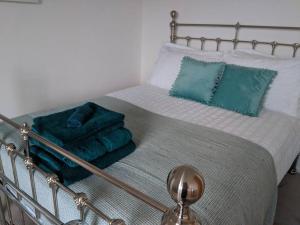 a bed with a metal frame with towels on it at Beach Front Coastal Retreat with Sea Views in Kingsbridge
