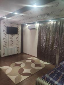 a room with a rug on the floor and a television at EAA in Tiraspol