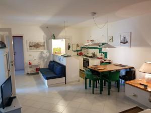 a kitchen and living room with a table and chairs at Giulianahouse in La Maddalena