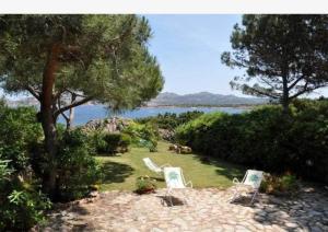 a group of lawn chairs sitting in the grass near the water at Giulianahouse in La Maddalena +36 photos