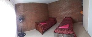 a small room with two beds and a fan at Departamento Ideal II! in Villa María