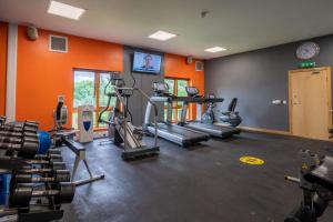 een fitnessruimte met cardio-apparatuur en een oranje muur bij Fell View in Troutbeck