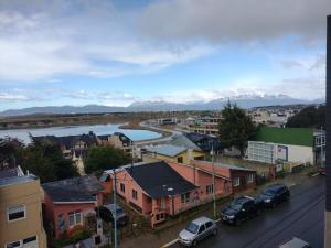 a city with cars parked on a street and a river at Departamento Bahía Grande in Ushuaia