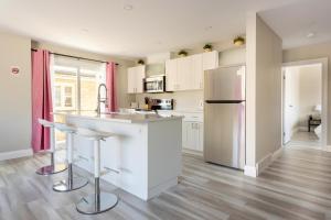 a kitchen with white cabinets and a stainless steel refrigerator at ENTIRE 2 BEDROOM APARTMENT DOWNTOWN - u2 in Kitchener