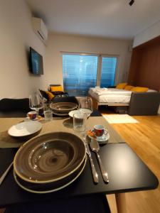 una sala de estar con una mesa con platos y copas de vino en Bed & Breakfast REZIDENCA PIPANOVA, en Liubliana