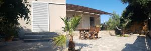 a patio with a table and chairs in front of a house at LOCANOMA in Corbara