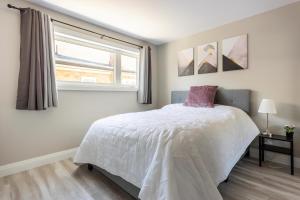 una camera con un letto bianco e una finestra di ENTIRE 2 BEDROOM APARTMENT DOWNTOWN - u2 a Kitchener
