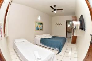 a room with two beds and a ceiling fan at Pousada A Flor da Terra in Arraial d'Ajuda