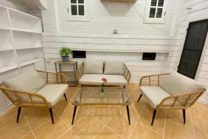 Whitehouse cafe&Guesthouse في Ban Sa La: فناء مع كرسيين وطاولة وأريكة