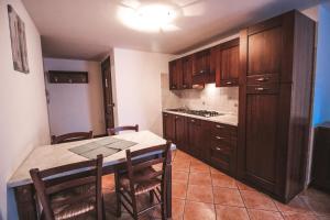 una cocina con armarios de madera y una mesa con sillas. en Residence Aquila - Bilo Testa di Comagna, en Brusson