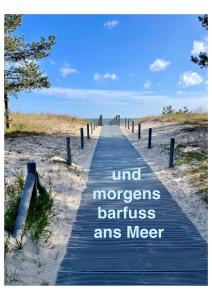 un chemin en bois jusqu'à la plage avec les mots “garde d'esprit” barriersnancenancenance dans l'établissement Villa Harmonie, à Ahlbeck