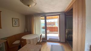 ein Wohnzimmer mit einem Tisch und einer Glastür in der Unterkunft Apartments Almiva in Kastelruth