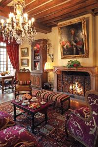 uma sala de estar cheia de mobiliário e um lustre em Hôtel Le Cep em Beaune