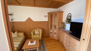a living room with a couch and a tv at Apartments Almiva in Castelrotto