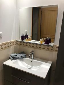 W łazience znajduje się biała umywalka i lustro. w obiekcie Ain’Time w mieście Biziat