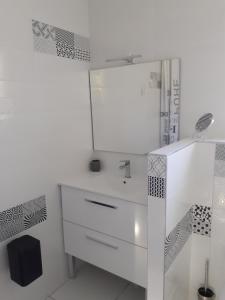bagno bianco con lavandino e specchio di Le MARINE a Saint-Martin-dʼArdèche