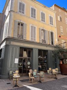 un magasin avec des chaises et des tables devant un bâtiment dans l'établissement L'appartement du Café de l'horloge, à La Ciotat