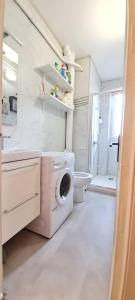 une salle de bains blanche pourvue d'un lave-linge. dans l'établissement Superbe appartement proche de toutes commodités., à Clermont-Ferrand