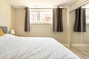 - une chambre avec un lit blanc et une fenêtre dans l'établissement ENTIRE 2 BEDROOM APARTMENT DOWNTOWN - u1, à Kitchener