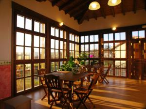 a dining room with a table and chairs and windows at Hotelapartamentos Torres in Selorio