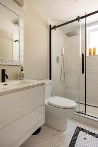 La salle de bains blanche est pourvue d'une douche et de toilettes. dans l'établissement ENTIRE 2 BEDROOM APARTMENT DOWNTOWN - u1, à Kitchener