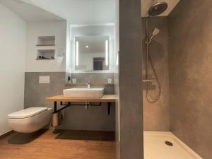 a bathroom with a sink and a toilet and a shower at Hotel am Sonnenlandpark in Lichtenau +16 photos