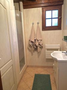 a bathroom with a sink and a shower with towels at Maison traditionnelle Normande avec piscine in Hotot-en-Auge
