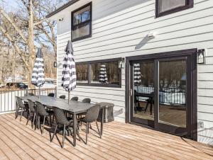 a patio with a table and chairs on a deck at Campfire Lodge - Luxury Cabin, Kid Friendly, Kaaterskill Falls, Hunter Mountain in Palenville