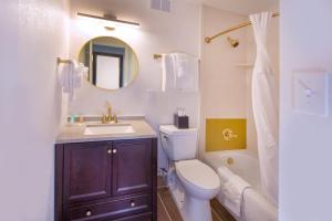 La salle de bains est pourvue de toilettes, d'un lavabo et d'un miroir. dans l'établissement Historic Whispering Woods Hotel & Conference Center, à Olive Branch