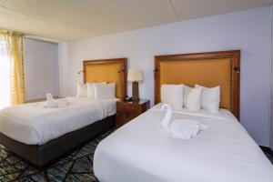- 2 lits dans une chambre d'hôtel avec des cygnes dans l'établissement Historic Whispering Woods Hotel & Conference Center, à Olive Branch