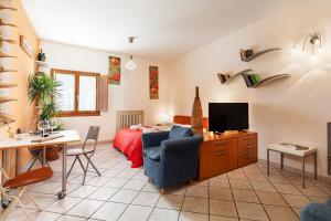 ein Wohnzimmer mit einem Bett und einem blauen Stuhl in der Unterkunft Casa Vacanze Alessandro 1 in Greve in Chianti